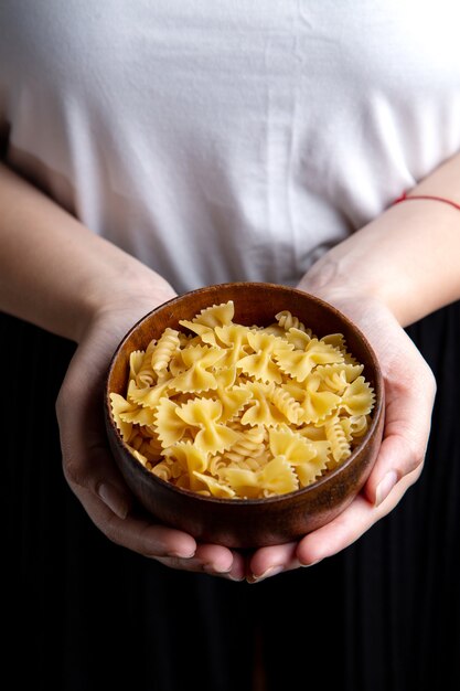 Una vista frontal hembra sosteniendo un plato de pasta con pasta italiana comida pasta italiana