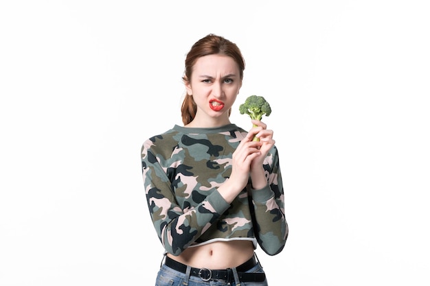Vista frontal de las hembras jóvenes con brócoli verde sobre fondo blanco, almuerzo, cuerpo, comida, ensalada, comida, dieta, salud, plato