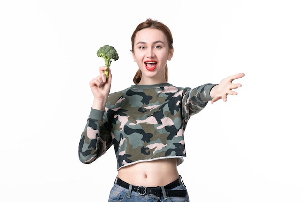 Vista frontal de las hembras jóvenes con brócoli verde sobre fondo blanco, dieta, comida sana, almuerzo, colores horizontales, cuerpo de comida