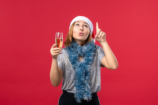 Vista frontal de las hembras jóvenes celebrando el año nuevo en el piso rojo color vacaciones navidad