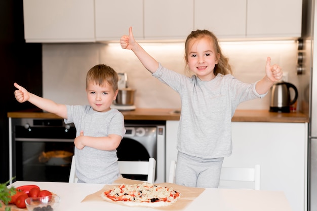 Foto gratuita vista frontal de hermanos cocinando en casa