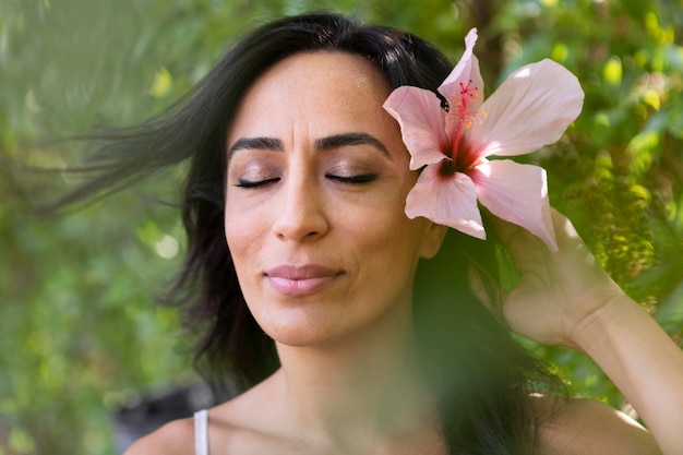 Vista frontal de la hermosa mujer al aire libre con flores en el cabello