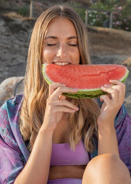 Vista frontal de la hermosa mujer comiendo sandía