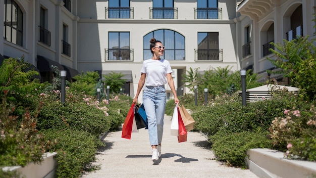 Foto gratuita vista frontal hermosa mujer posando con bolsas de la compra.