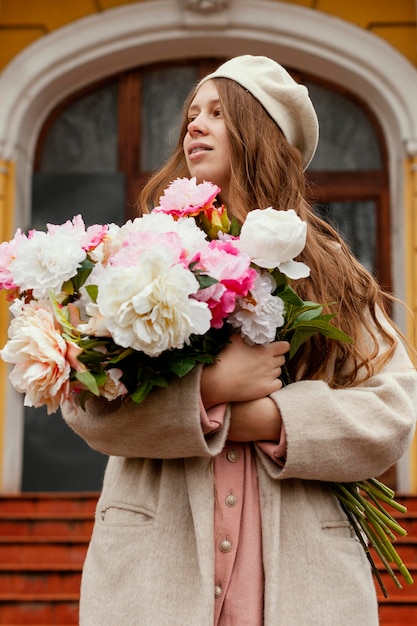 Vista frontal de la hermosa mujer con ramo de flores