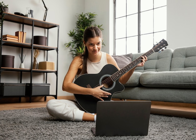 Vista frontal de la hermosa mujer tocando la guitarra