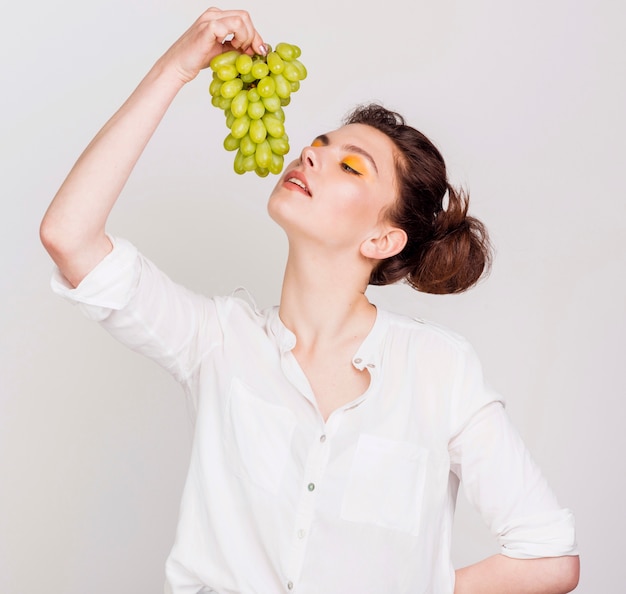 Vista frontal de hermosa mujer con uvas