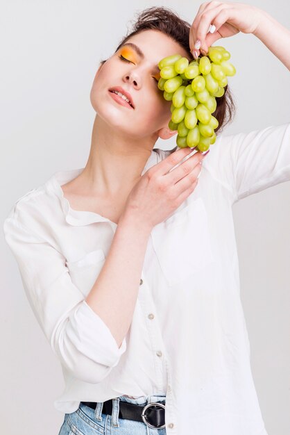 Vista frontal de hermosa mujer con uvas