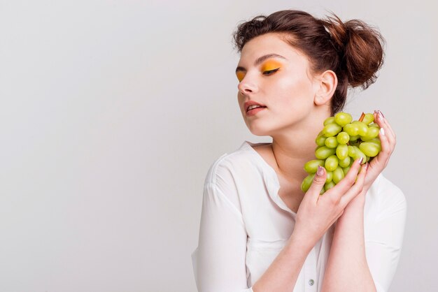 Vista frontal de hermosa mujer con uvas
