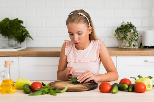 Vista frontal de la hermosa niña cocinando