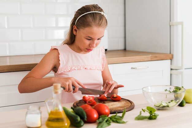 Vista frontal de la hermosa niña cocinando