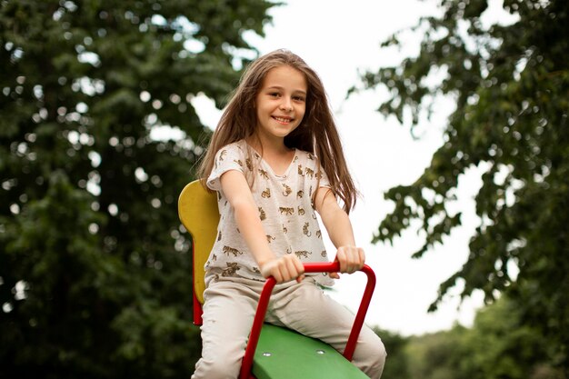 Vista frontal de la hermosa niña feliz en el parque