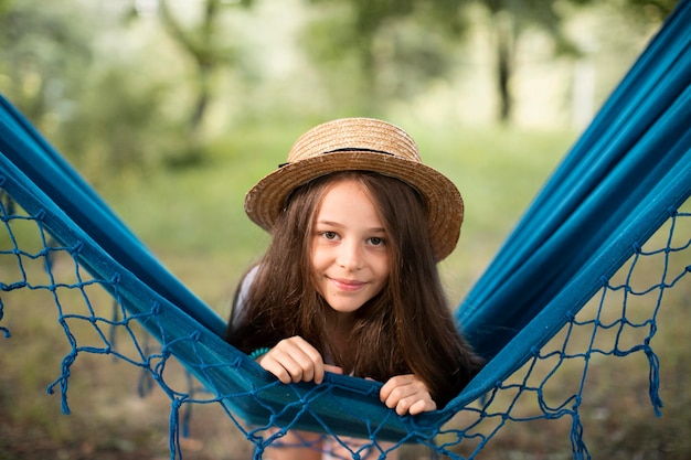 Foto gratuita vista frontal de la hermosa niña sonriente en hamaca