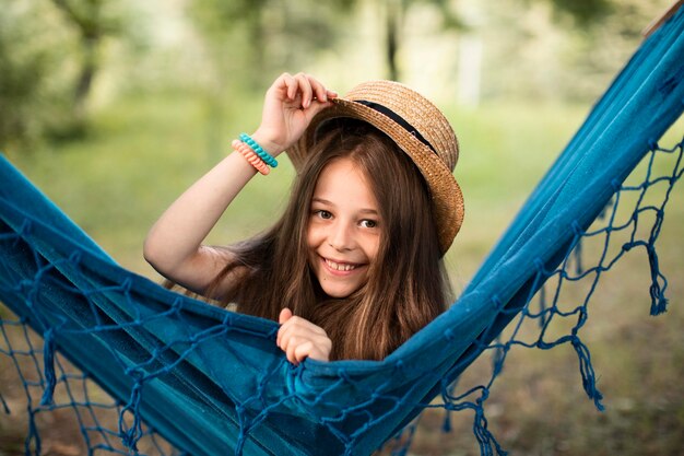 Vista frontal de la hermosa niña sonriente en hamaca