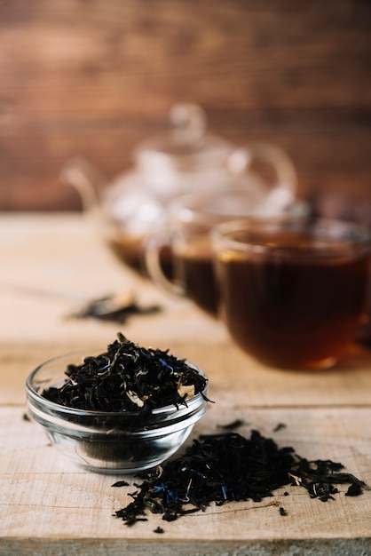 Vista frontal de hierbas de té negro con fondo borroso