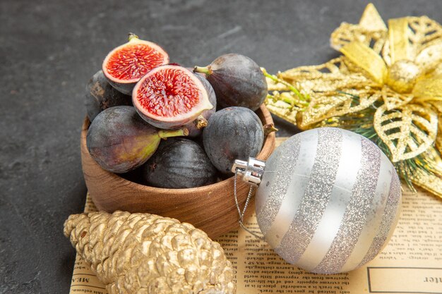 Vista frontal de higos frescos con juguetes de árbol de navidad sobre fondo oscuro árbol de frescura fotográfica en color de frutas