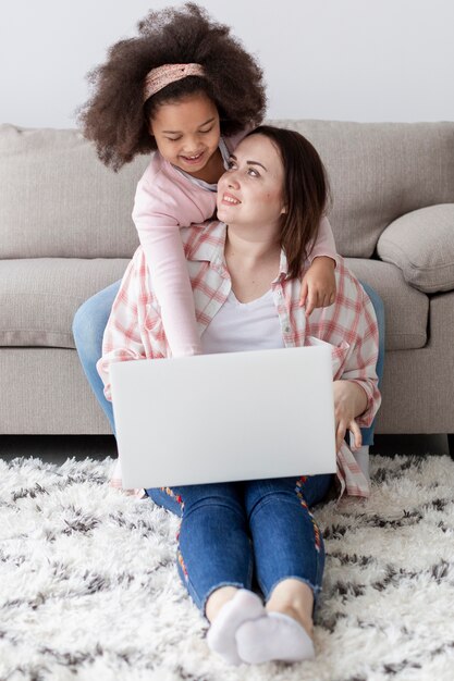 Vista frontal hija feliz de estar con la madre en casa