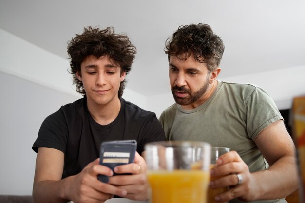 Vista frontal hombre y adolescente con jugo