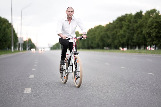 Vista frontal hombre adulto montando bicicleta en la calle