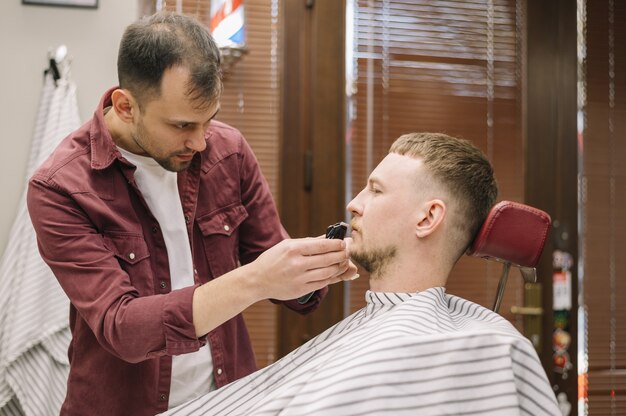 Vista frontal del hombre afeitándose la barba