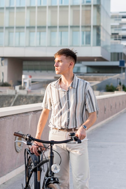 Vista frontal del hombre al aire libre con bicicleta