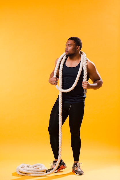 Vista frontal del hombre atlético en traje de gimnasio con cuerda