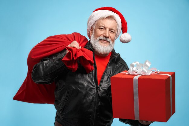 Vista frontal del hombre barbudo con gorro de Papá Noel con cajas de regalo