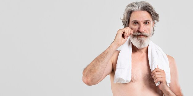 Vista frontal del hombre barbudo senior con toalla