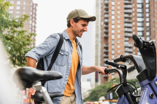 Vista frontal hombre con bicicleta en la ciudad