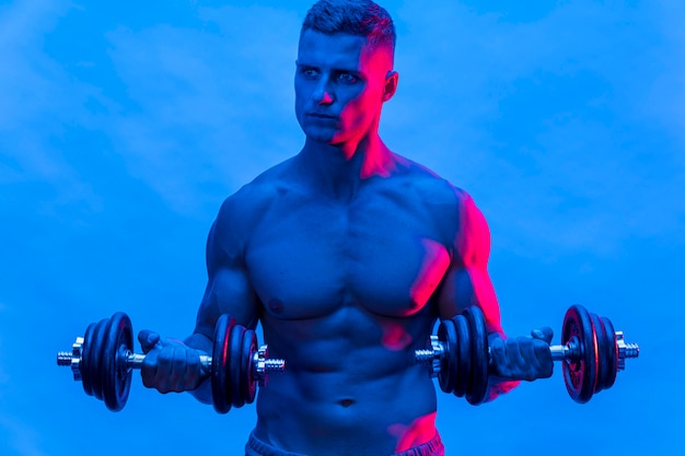 Vista frontal del hombre sin camisa en forma entrenando con pesas