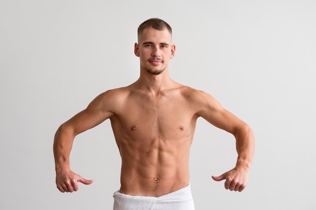 Foto gratuita vista frontal del hombre sin camisa mostrando su cuerpo