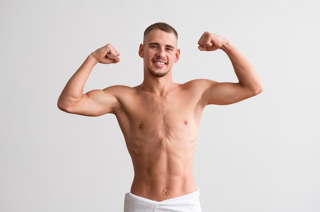 Foto gratuita vista frontal del hombre sin camisa mostrando sus bíceps