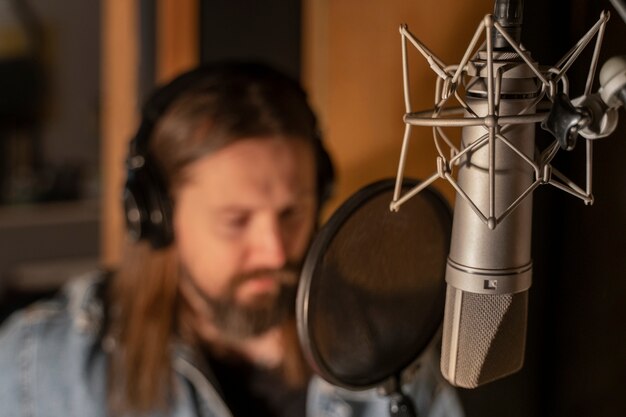 Vista frontal hombre cantando en estudio