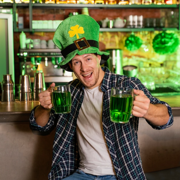 Foto gratuita vista frontal del hombre celebrando st. patrick's day en el bar con bebidas