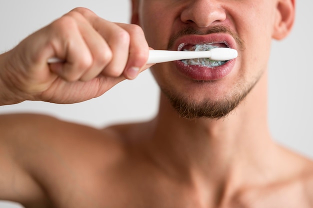 Vista frontal del hombre cepillándose los dientes