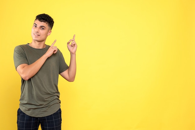 Vista frontal de un hombre, el chico sonriente está pensando y apuntando hacia arriba