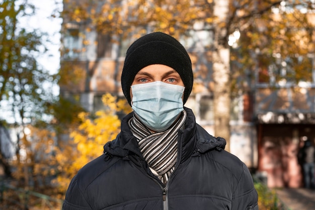 Vista frontal del hombre en la ciudad con máscara médica
