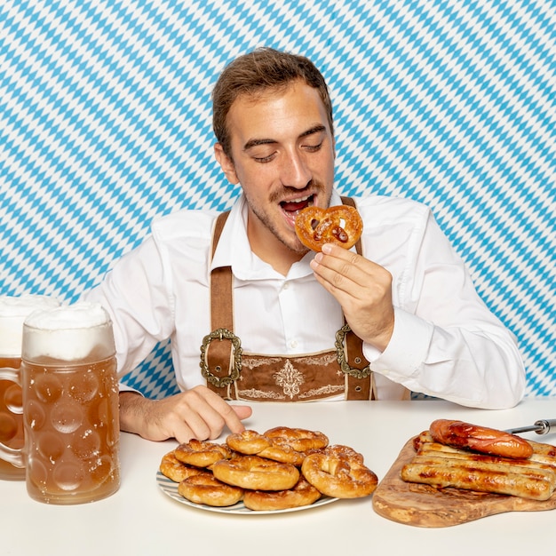 Foto gratuita vista frontal del hombre comiendo pretzels alemanes