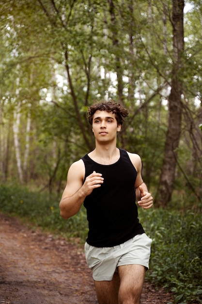 Vista frontal hombre corriendo en la naturaleza