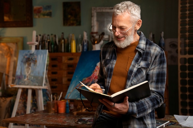 Vista frontal hombre con cuaderno de dibujo