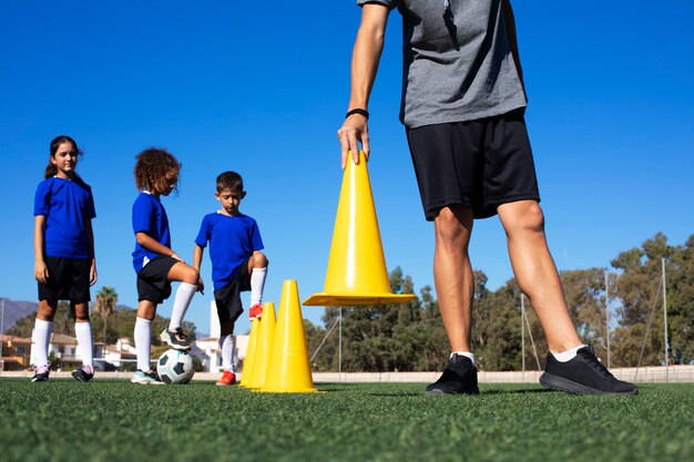 Vista frontal hombre entrenando niños