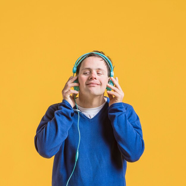 Vista frontal del hombre escuchando música con auriculares