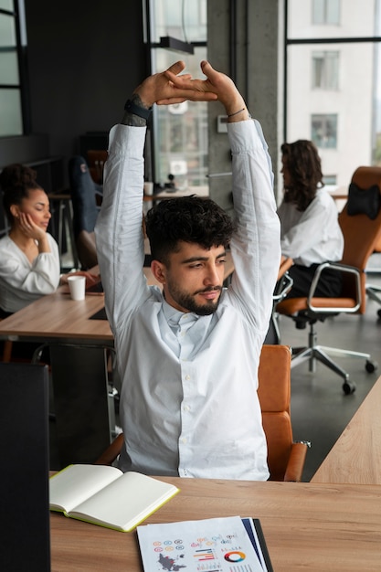 Foto gratuita vista frontal hombre estirando en el trabajo