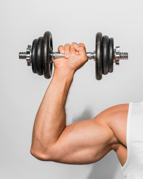 Vista frontal del hombre en forma sosteniendo pesas