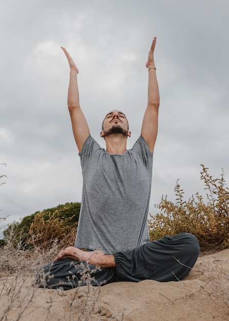 Foto gratuita vista frontal del hombre fuera de practicar yoga