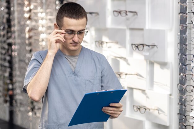 Vista frontal del hombre con gafas y mirando el bloc de notas