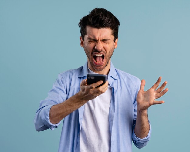 Vista frontal del hombre gritando en el teléfono inteligente