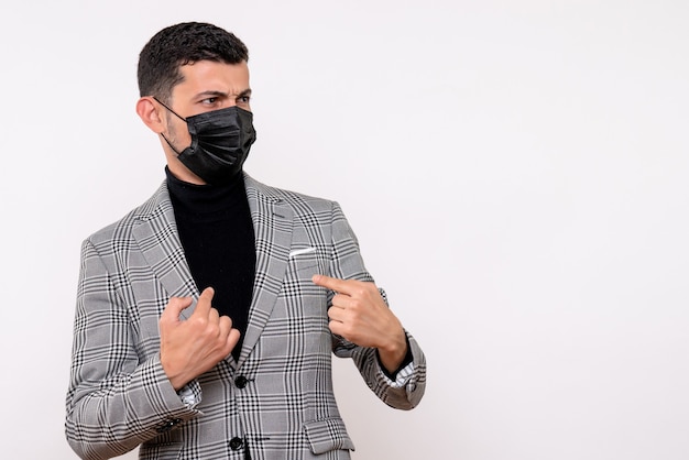 Vista frontal hombre guapo en traje apuntando a sí mismo de pie sobre fondo blanco aislado