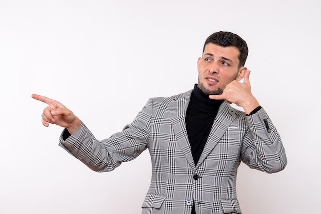 Vista frontal hombre guapo en traje haciendo gesto de llamarme teléfono de pie sobre fondo blanco aislado