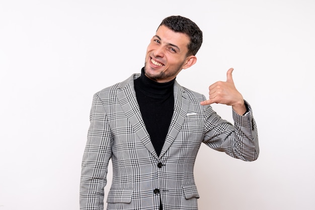 Vista frontal hombre guapo en traje haciendo gesto de llamarme teléfono de pie sobre fondo blanco.